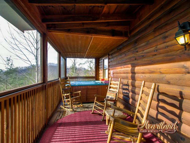 Hot tub and rocking chairs on the screened in porch